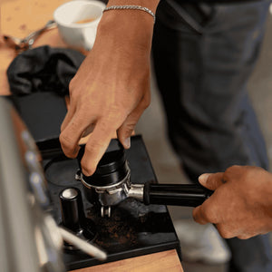 Richtiges Tampern des Kaffeepucks als Teil der Espresso-Zubereitung im Espresso Lab Barista Kurs für Fortgteschrittene.