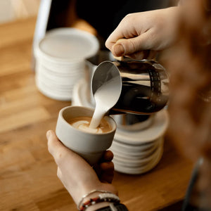 Teilnehmerin gießt Latte Art im Latte Art Kurs der CARLES Kaffeeschule in Kaarst bei Düsseldorf