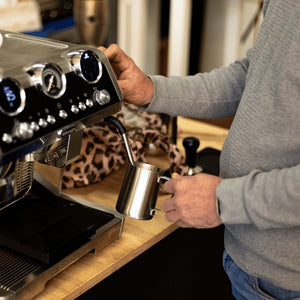 Teilnehmer lernt das richtige Milchschäumen für Cappuccino und Latte Art im Barista Kurs.